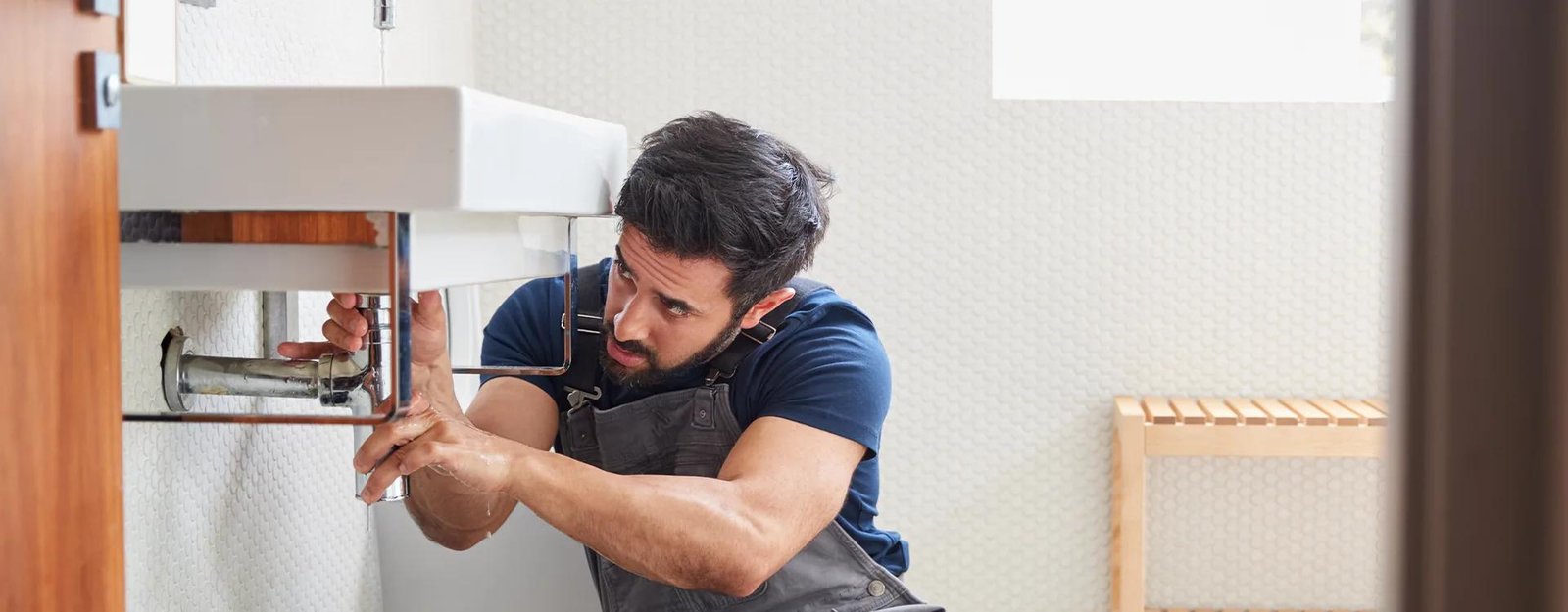 Plombier réparant un lavabo de salle de bain